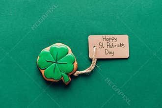 top view of icing cookie in shape of shamrock on green, st patricks day concept