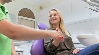4k video of happy smiling woman shaking hands with dentist after teeth treatment