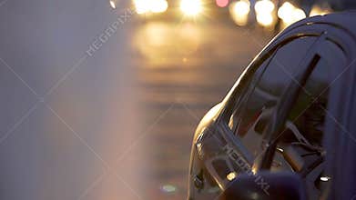 Blurred car with bright headlights slowly driving on parking lot, auto park