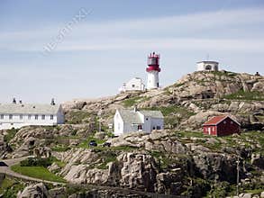Photo of Lindesnes beacon in summer, South Norway. Aerial shot. Rocky sea coast and blue sky.