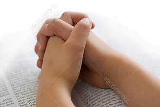 Praying hands on bible