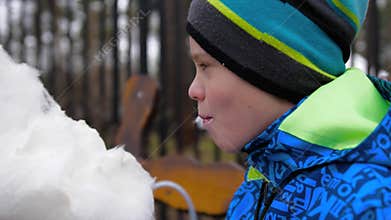 Baby eating cotton candy in the Park. Sweet and airy dessert