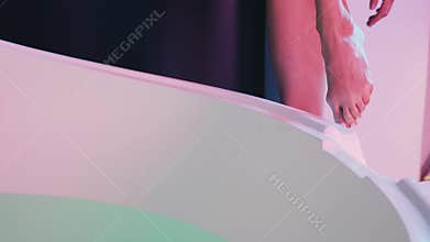 Young woman entering Spa bath or swimming pool, she is very relaxed. Welness concept