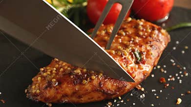 Cooking fried roasted chicken breasts cut knife with lemon tomato and rosemary mustard seeds honey
