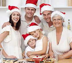 Smiling family baking Christmas cakes
