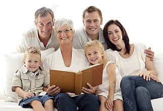 Grandmother reading a book to her family