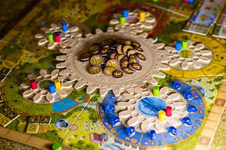 Colorful boardgame with cogwheels, figurines, chips and playing cards