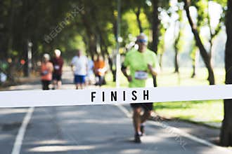 Mature man running towards the finish line