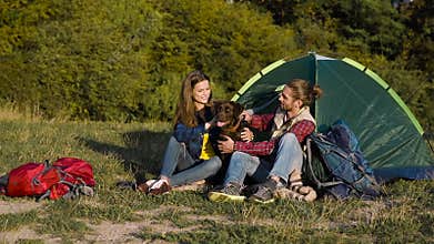 Man and woman traveling with dog at camp