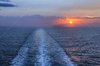 Sea horizon at sunset with ship wake.