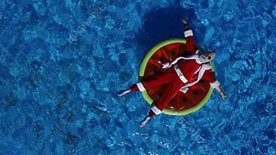 Party Santa in swimming pool on watermelon float
