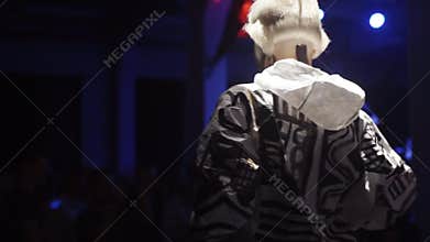 Girl in futuristic costume is dancing at the nihgtclub` s scene