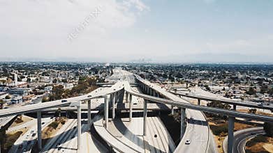 Drone flying forward over epic multiple level highway intersection in Los Angeles, traffic moving in all directions.