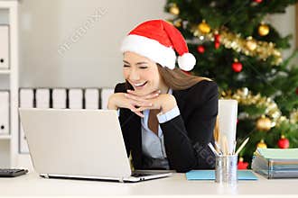 Happy employee reading on line at office in christmas