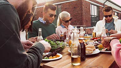 Friends having dinner or bbq party on rooftop