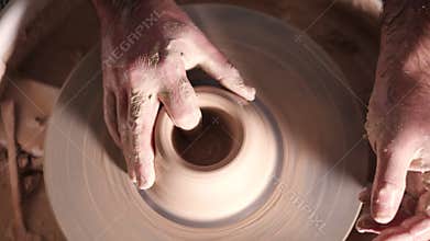 Creating earthenware and traditional pottery concept. Experienced male potter`s hands creating beautiful clay product -