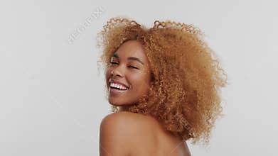 Mixed race woman with big curly afro blonde hair in studio