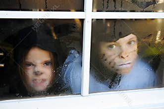 Children behind a window with raindrops