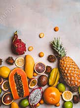 top view of pineapple, blood oranges, rambutans, pitayas, passion fruits, kumquats, papayas, carambola, mango and limes on marble