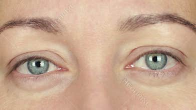 Woman open eyes and blinking front camera. Close up face adult woman winking eye