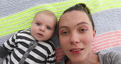 Mother and newborn are lying top view close up