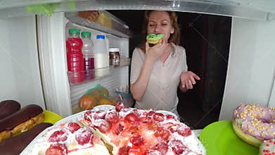 Woman opens the refrigerator at night. night hunger. diet gluttony