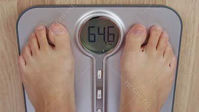 Top view human foot stepping on weighting scale for measuring body mass