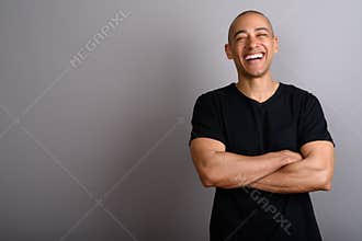 Happy bald man smiling and laughing with arms crossed