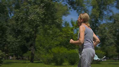 Senior man and woman jogging in park, health care, active people slow-motion