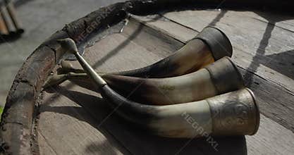 Three horns for drinking wine on wooden barrel
