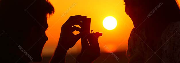 Banner of silhouette of marriage proposal at sunset