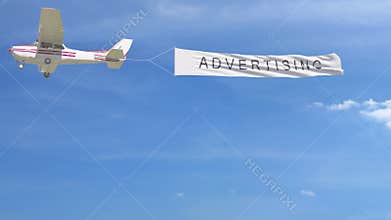 Small propeller airplane towing banner with ADVERTISING caption in the sky
