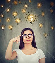 Woman looking up at dollar idea light bulbs above head deciding how to earn morney