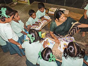 Group of children friends classmates studying with book sitting on floor indoors at the school. School kids enjoying friendship