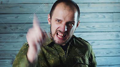 Portrait of angry officer soldier. The crazy captain of the army is swearing and yelling.