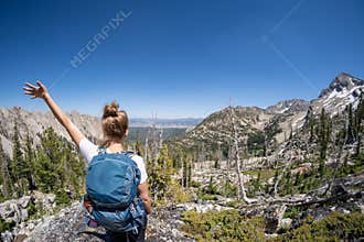 Female hiker with backpack along the Sawtooth Lake trail in Idaho. Back facing camera. Concept for solo female travel and hiking