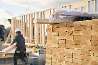 Stacked Lumber and Blueprints at a Construction Si