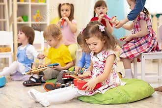 Children learning musical instruments on lesson in kindergarten