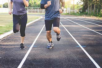 Early morning workout, Fitness couple stretching outdoors in park. Young man and woman exercising together in morning, Living