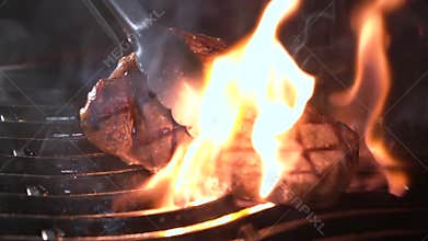 Beef steak on the grill with flames
