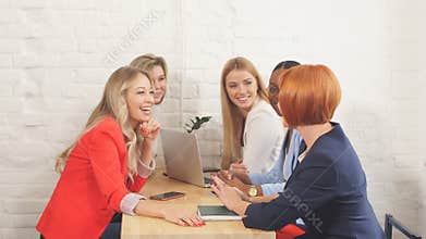 Group of young women discussing project during work process with laptop.