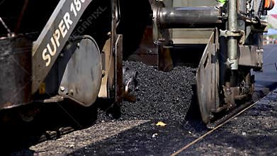 Asphalt making machine pours asphalt onto prepared road