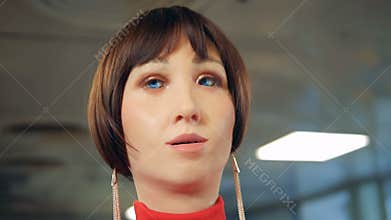 Droid with female face talking, close up.