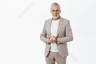 Portrait of smart and handsome intelligent senior male professor in stylish suit and glasses holding hands together