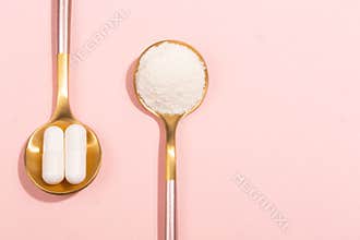 Collagen powder and pills on pink background