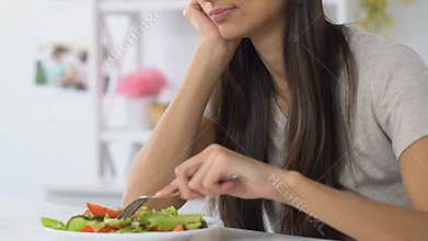 Woman sighing heavily looking at vegetable salad, having no appetite, diet