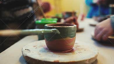 Potter`s wheel in the pottery workshop. Handcraft Pottery inside. kids Hands working on pottery wheel, shaping a clay