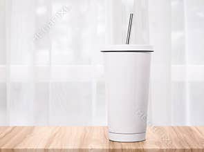 Steel mug on morning backdrops. Insulated drink container
