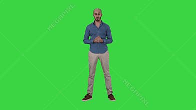 Casual arab man talking to camera explaining something on a Green Screen, Chroma Key.