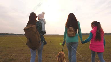 Family travels with the dog on the plain. Teamwork of a close-knit family. Mother, little child and daughters and pets